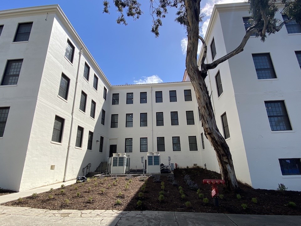 Newly rehabilitated west elevation of Building 205. Exterior staircases have been removed, new landscaping. 